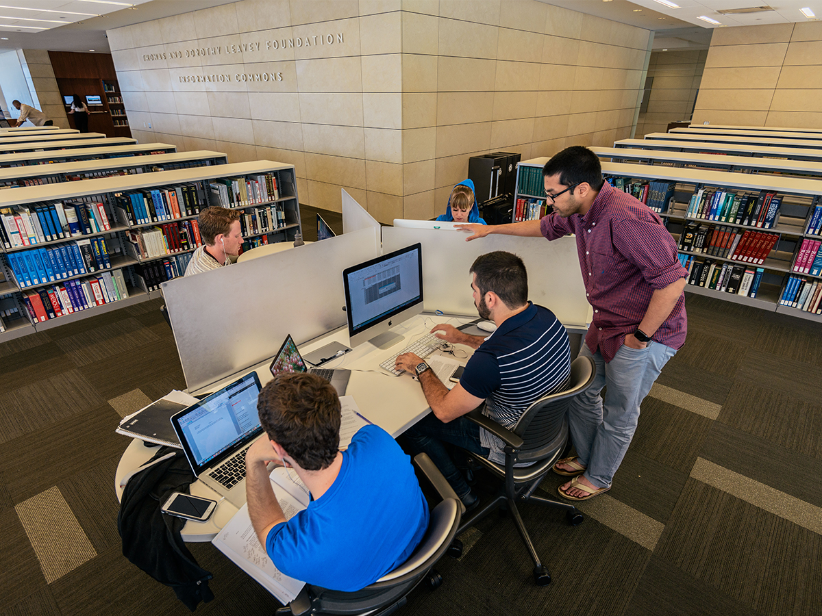 Students looking at a computer screen inside library