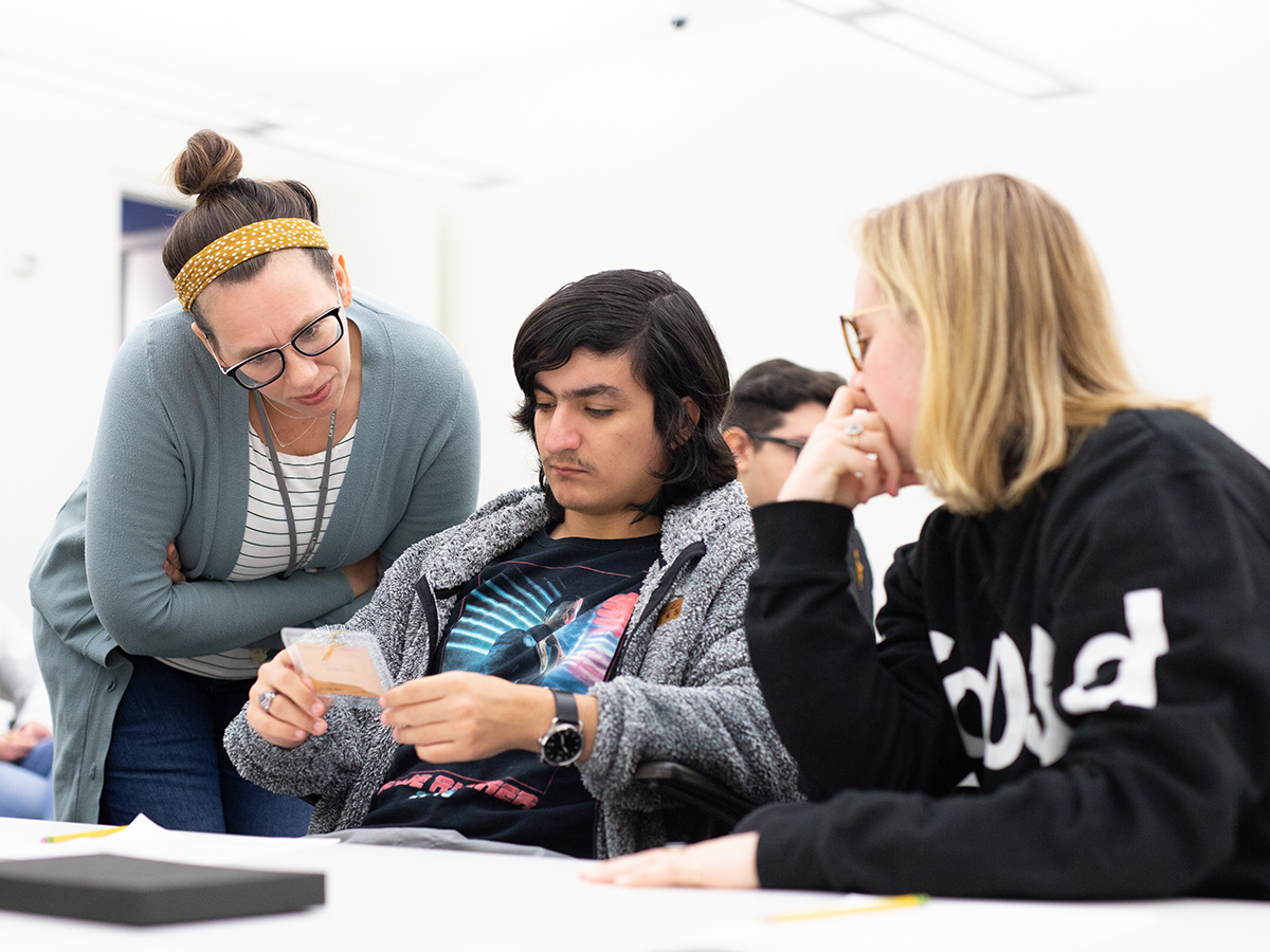 Three students examining object