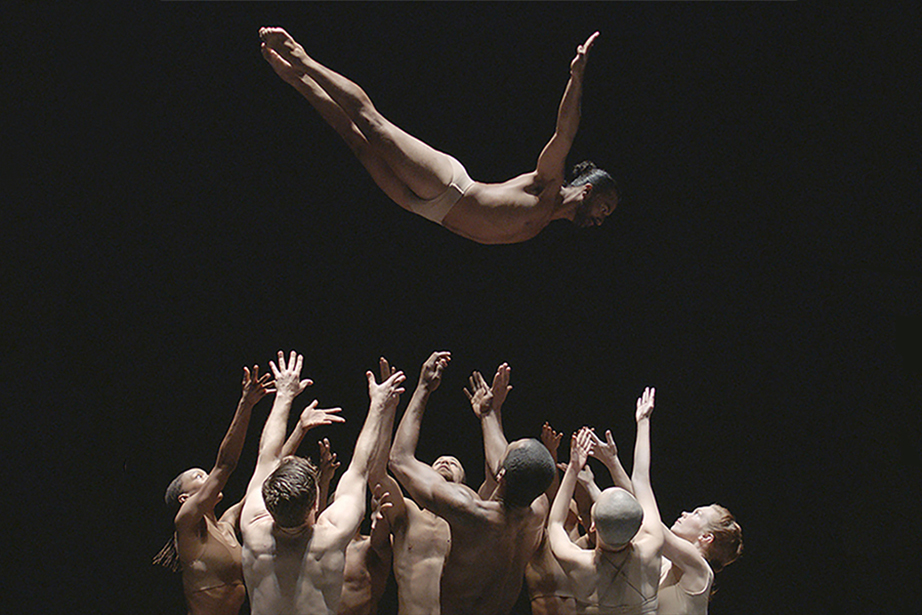 Group of dancers throwing dancer into the air
